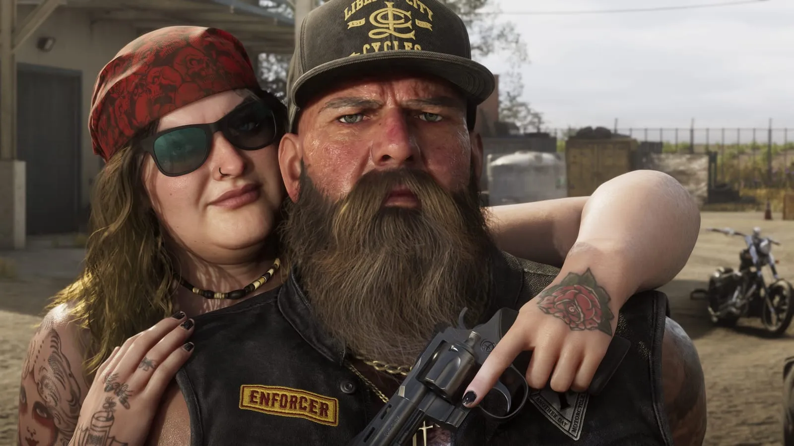 Close portrait of a bearded biker wearing an Enforcer patch and a woman in a red bandana, revolver in hand