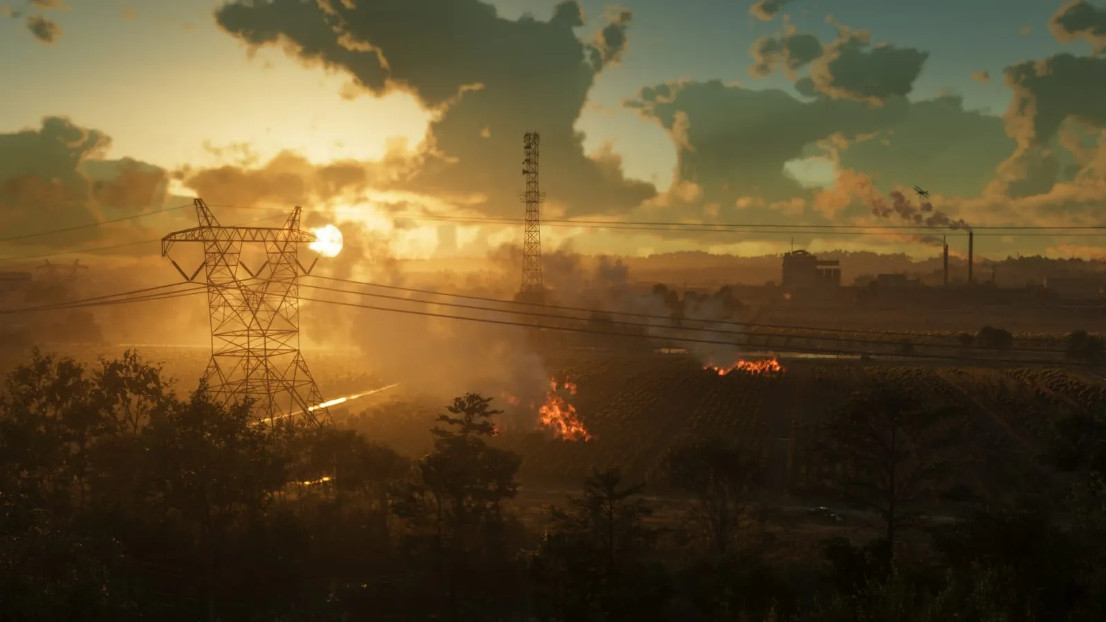Fields burning at sunset beneath power lines, a plant smoking on the horizon