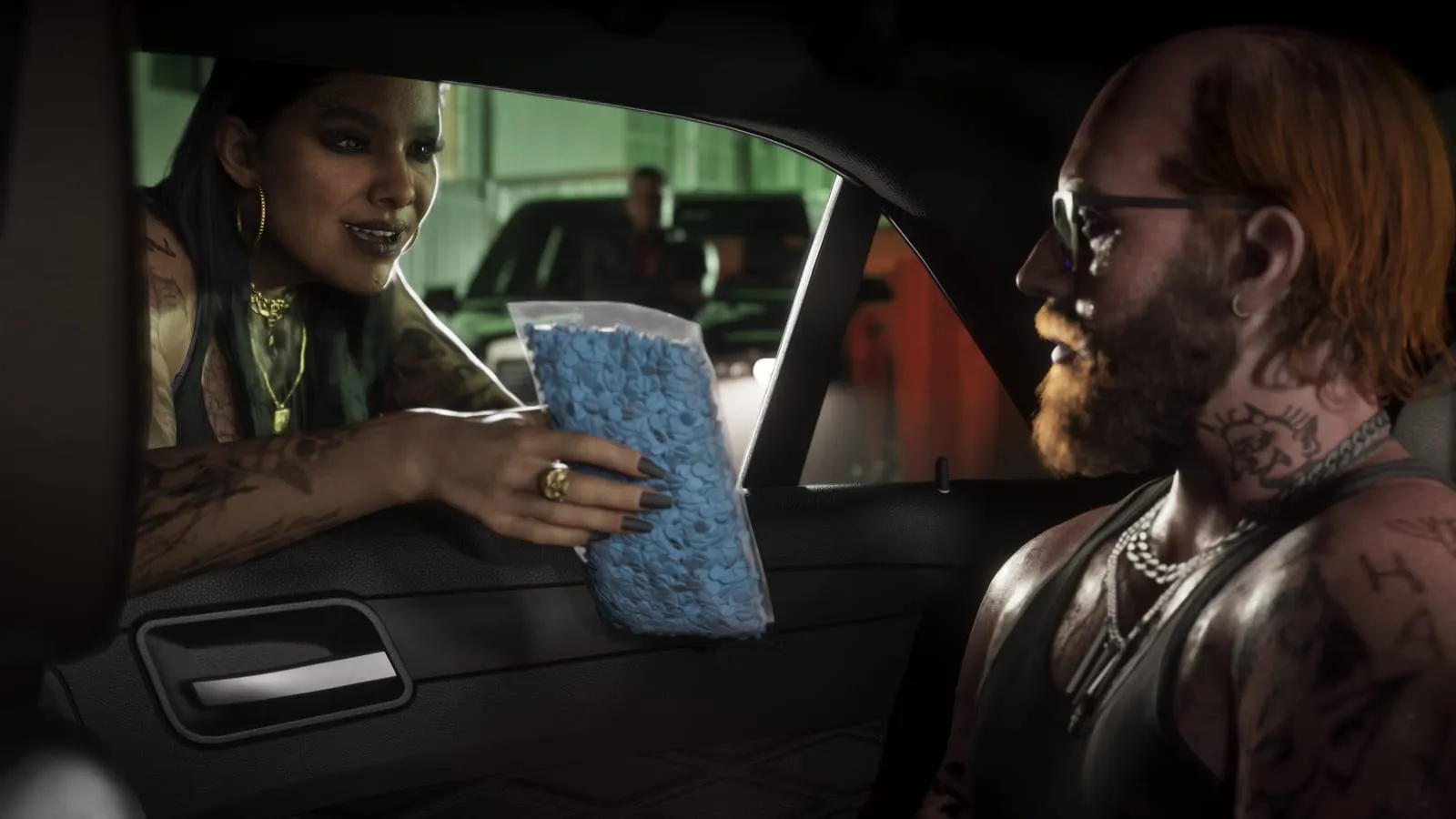 Une femme tatouée tend un sachet de comprimés bleus par la vitre à un conducteur roux barbu