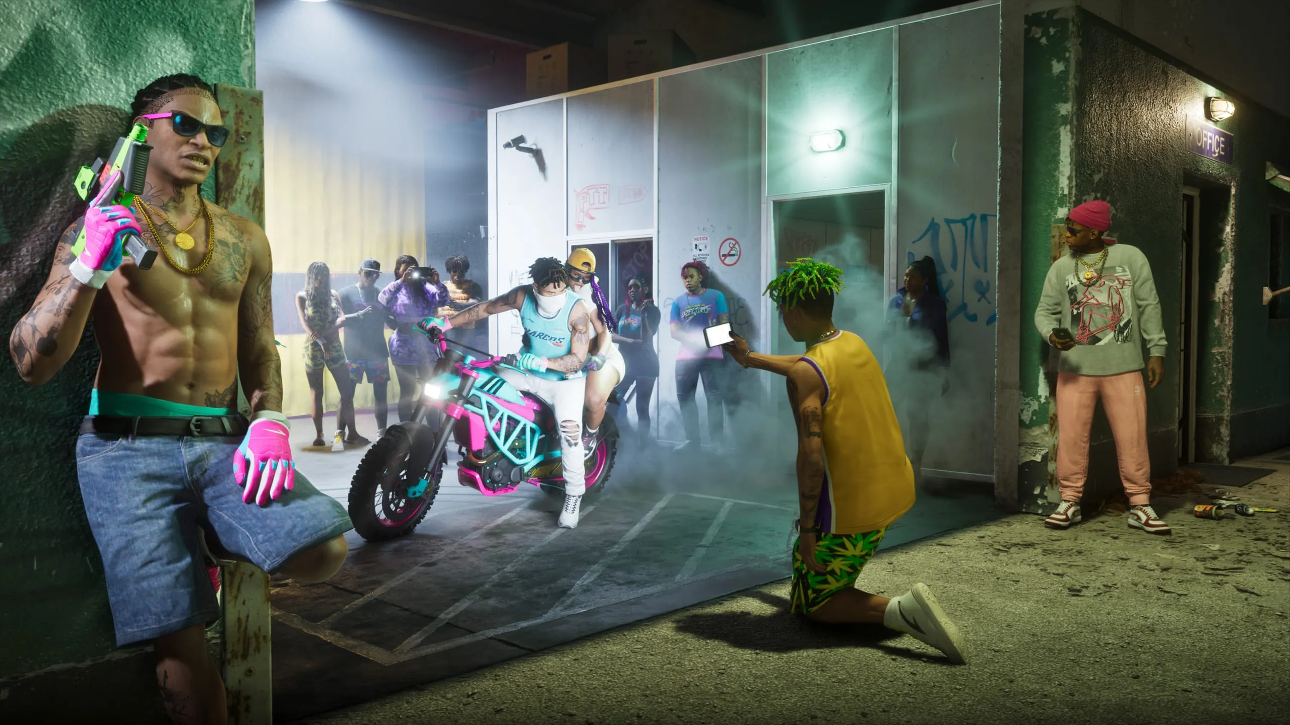 Night shoot in a garage yard around a pink and teal dirt bike, smoke drifting under a work light