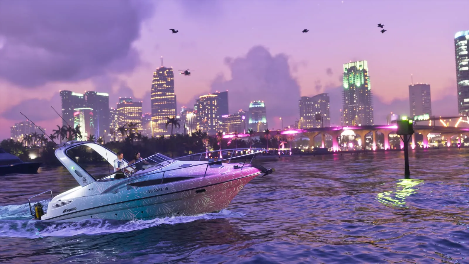 Pink and teal Squalo speedboat cutting across the bay with the lit city skyline behind