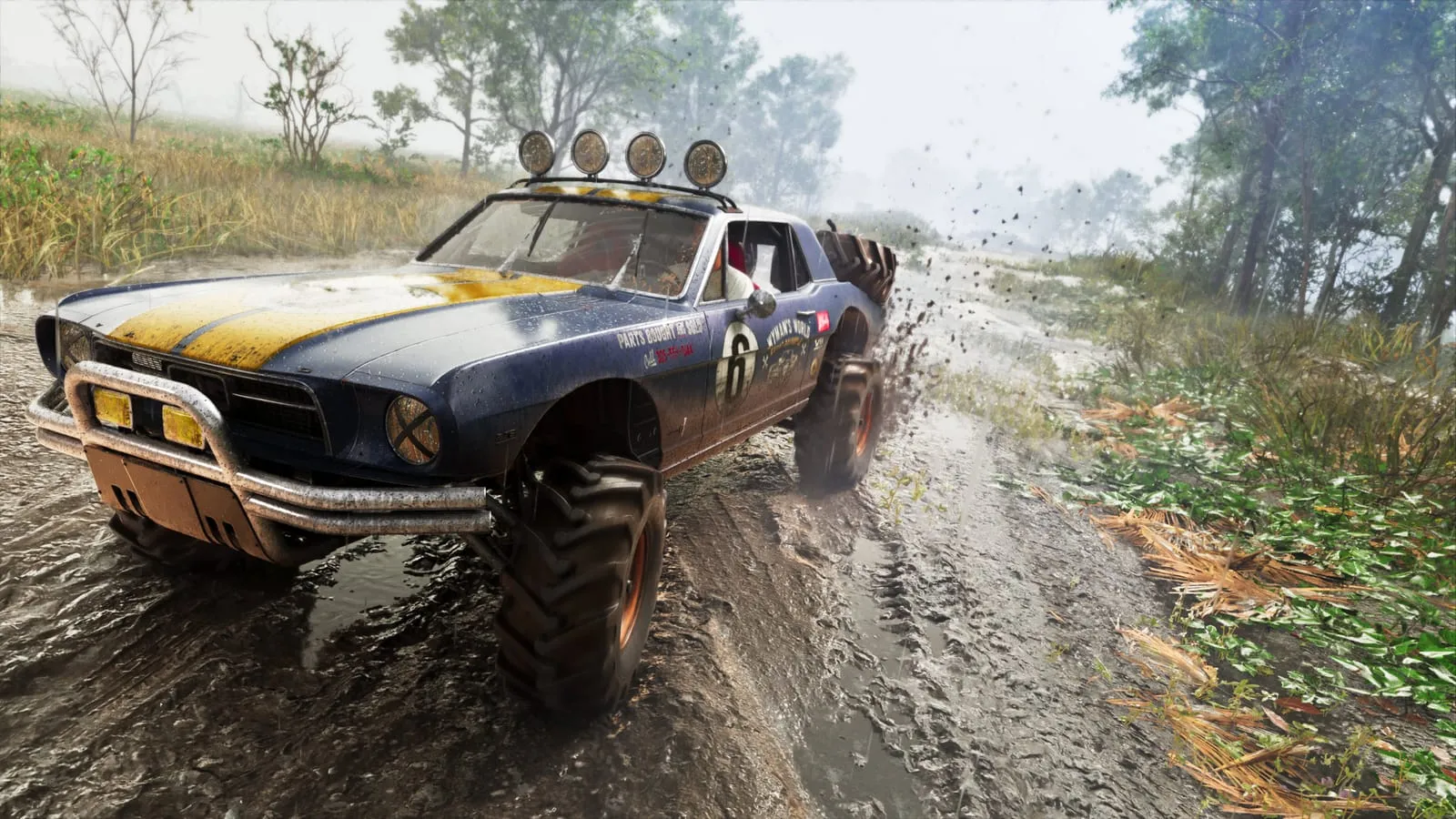 Blue muscle car turned off-road buggy blasting through mud on a rain-soaked trail