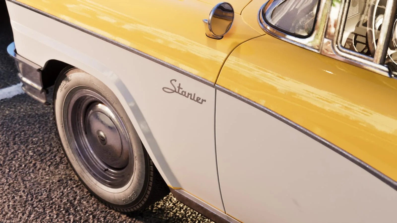 Close detail of a vintage sedan's fender showing the Stanier script and whitewall tire